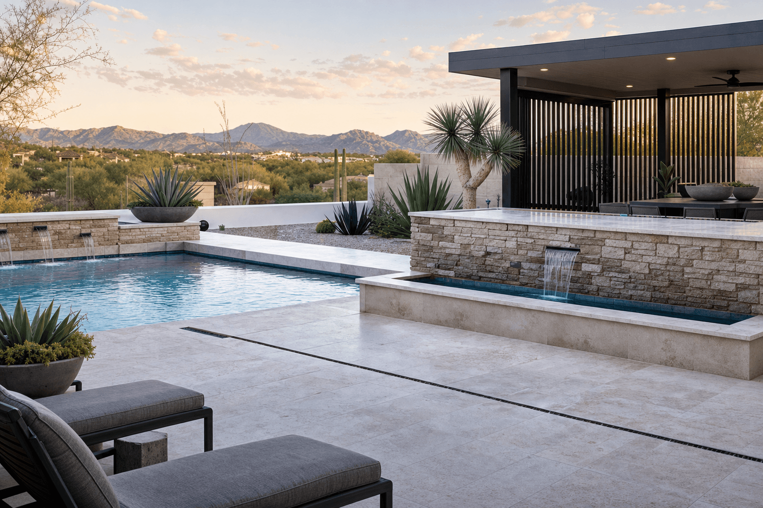 Travertine hardscape beside a geometric pool and water feature