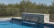 Remodeled pool with sheer descent water feature and stacked stone wall